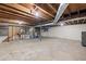 Unfinished basement features concrete floor, block walls, exposed ceilings, and wooden staircase at 9588 Poston Rd, Jonesboro, GA 30238
