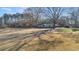 Quaint house with carport situated on a grassy lawn, surrounded by mature trees at 9588 Poston Rd, Jonesboro, GA 30238