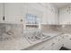 Bright kitchen with stainless steel sink, white cabinets, and granite countertops at 9588 Poston Rd, Jonesboro, GA 30238