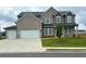 Charming two-story brick home featuring a three-car garage and landscaped front yard at 98 Longhorn Way, Auburn, GA 30011