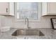 Close-up of a kitchen sink with granite countertops and white subway tile backsplash at 98 Longhorn Way, Auburn, GA 30011