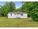 Charming single-story home with white painted brick, dark roof, green lawn and mature trees at 1350 Redford Se Dr, Atlanta, GA 30315