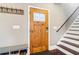 Warm entryway with a wooden door, coat rack, storage bench, and staircase at 1977 Nash Se Ave, Atlanta, GA 30316