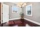 Bright living room featuring a modern chandelier, two windows, and lustrous hardwood flooring at 1977 Nash Se Ave, Atlanta, GA 30316