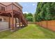 Backyard features a well-maintained lawn, a wood fence, and a staircase leading up to a deck at 3845 New Salem Ct, Cumming, GA 30040