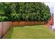 Fully fenced backyard featuring a lush lawn and mature trees at 3845 New Salem Ct, Cumming, GA 30040
