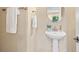A pedestal sink features a round mirror, accompanied by towel racks and neutral wall color at 3845 New Salem Ct, Cumming, GA 30040