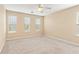 Spacious bedroom featuring neutral carpet, natural light from multiple windows, and a ceiling fan at 3845 New Salem Ct, Cumming, GA 30040