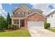 Charming two-story brick home with a well-manicured lawn, two-car garage, and inviting front porch at 3845 New Salem Ct, Cumming, GA 30040