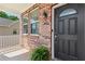 Welcoming covered brick porch featuring a black front door and decorative fern at 3845 New Salem Ct, Cumming, GA 30040