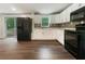 Modern kitchen featuring white cabinets, black appliances, and stylish backsplash at 4239 Canby Ln, Decatur, GA 30035