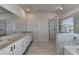 Sleek bathroom with double vanity, tiled floor, glass shower, and large mirror at 58 Longhorn Way, Auburn, GA 30011