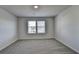Neutral bedroom with light colored carpet, walls, and single window at 58 Longhorn Way, Auburn, GA 30011