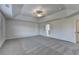 Large bedroom with gray carpet, tray ceiling, and multiple doorways at 58 Longhorn Way, Auburn, GA 30011