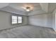Spacious bedroom with tray ceiling, large window, and neutral carpeting at 58 Longhorn Way, Auburn, GA 30011
