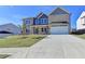 Two-story home with green lawn, and a two-car garage showing a neutral brick elevation at 58 Longhorn Way, Auburn, GA 30011