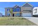 Charming two-story home with a well-kept lawn, a two-car garage and a lovely tree in the yard at 58 Longhorn Way, Auburn, GA 30011
