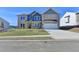 Beautiful new home with a manicured front yard, two-car garage, and neutral brick at 58 Longhorn Way, Auburn, GA 30011