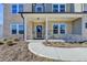 Inviting front porch with stylish columns and brickwork, enhanced by lush landscaping at 58 Longhorn Way, Auburn, GA 30011