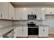Clean kitchen with stainless steel appliances and granite countertops and backsplash at 58 Longhorn Way, Auburn, GA 30011