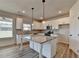 Bright kitchen features an island with granite countertops and stainless steel appliances at 58 Longhorn Way, Auburn, GA 30011