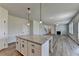 Open-concept kitchen with granite island and hardwood floors lead to the living area at 58 Longhorn Way, Auburn, GA 30011