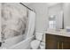 Bathroom features tiled walls, tub, and shower with updated vanity and fixtures at 635 Broadview Ne Pl, Atlanta, GA 30324