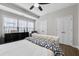 Bedroom with a large window, modern ceiling fan, tufted headboard and neutral decor at 635 Broadview Ne Pl, Atlanta, GA 30324