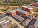 Expansive aerial view showcasing red brick multi-unit building with parking nestled among lush greenery and nearby homes at 4143 N Swann St, Covington, GA 30014