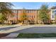 Brick multi-unit building with yellow doors and mature landscaping offers a charming and upscale living experience at 4143 N Swann St, Covington, GA 30014