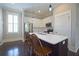 Bright kitchen with stainless steel appliances, white cabinets, island, and dark wood floors at 4143 N Swann St, Covington, GA 30014