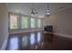 Bright living room featuring four large windows with shutters, ceiling fan, and dark hardwood floors at 4143 N Swann St, Covington, GA 30014