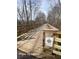 Scenic wooden bridge with railing, surrounded by lush trees, creates a peaceful trail experience at 4143 N Swann St, Covington, GA 30014