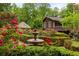 Picturesque garden with a tiered fountain, vibrant rose bushes, manicured hedges, and a charming gazebo amidst lush greenery at 44 Muscogee Nw Ave, Atlanta, GA 30305