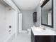 Full bathroom with tub and shower, white tiled walls, and a dark vanity at 744 Oakland Se Ave, Atlanta, GA 30315