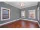Spacious bedroom with wood floors, 3 windows, and gray walls at 744 Oakland Se Ave, Atlanta, GA 30315