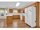 Functional kitchen with wooden cabinets, white appliances, and a breakfast bar at 1561 Oak Ivy Ln, Lawrenceville, GA 30043