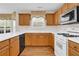 Well-equipped kitchen featuring wood cabinets, white countertops, and standard appliances at 1561 Oak Ivy Ln, Lawrenceville, GA 30043