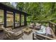 An outdoor deck featuring stylish furniture, a wood railing, and overlooking a lush, green backyard at 1860 Mountain Shadow, Stone Mountain, GA 30087