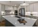 Close up of kitchen island featuring white countertops, a stainless steel sink, and dining set at 1860 Mountain Shadow, Stone Mountain, GA 30087