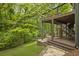 Multi-level outdoor patio with lush greenery, wooden decks, a swing chair, and stylish design, perfect for relaxation at 1860 Mountain Shadow, Stone Mountain, GA 30087