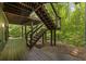 Wood patio with stairs leading to a serene backyard, surrounded by lush greenery and natural light, perfect for relaxation at 1860 Mountain Shadow, Stone Mountain, GA 30087