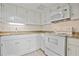 Bright kitchen with granite countertops, white appliances, and white cabinetry at 2117 Bucktrout Pl, Dunwoody, GA 30338