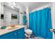 Bright bathroom featuring a blue vanity, matching shower curtain, and organized towel storage at 4079 Essex Dr, Villa Rica, GA 30180