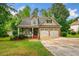 A charming two-story home features a covered front porch, stone accents, and a well-kept lawn at 4079 Essex Dr, Villa Rica, GA 30180