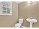 Cozy half bathroom featuring a pedestal sink and a window for natural light at 1558 Park Knoll Trl, Lawrenceville, GA 30043