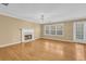 Cozy living room with a fireplace, hardwood floors, and natural light at 1558 Park Knoll Trl, Lawrenceville, GA 30043