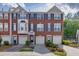 Charming brick townhome featuring a two-car garage, complemented by neat landscaping at 3194 Mill Springs Cir, Buford, GA 30519