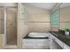 Bathroom featuring a soaking tub, glass enclosed shower, and tile surround creating a spa-like retreat at 4700 Township Walk, Marietta, GA 30066
