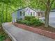 Charming home with well-maintained landscaping, a brick retaining wall, and a driveway, set amongst lush trees at 4700 Township Walk, Marietta, GA 30066